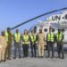 UNSOS, Somali and African Union personnel beside a United Nations helicopter at Mogadishu airport